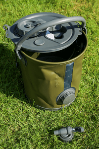 Faltkanister im Test: Der Wasserkanister von Colapz steht mit geöffnetem Deckel im Gras und davor liegt der Zapfhahn.