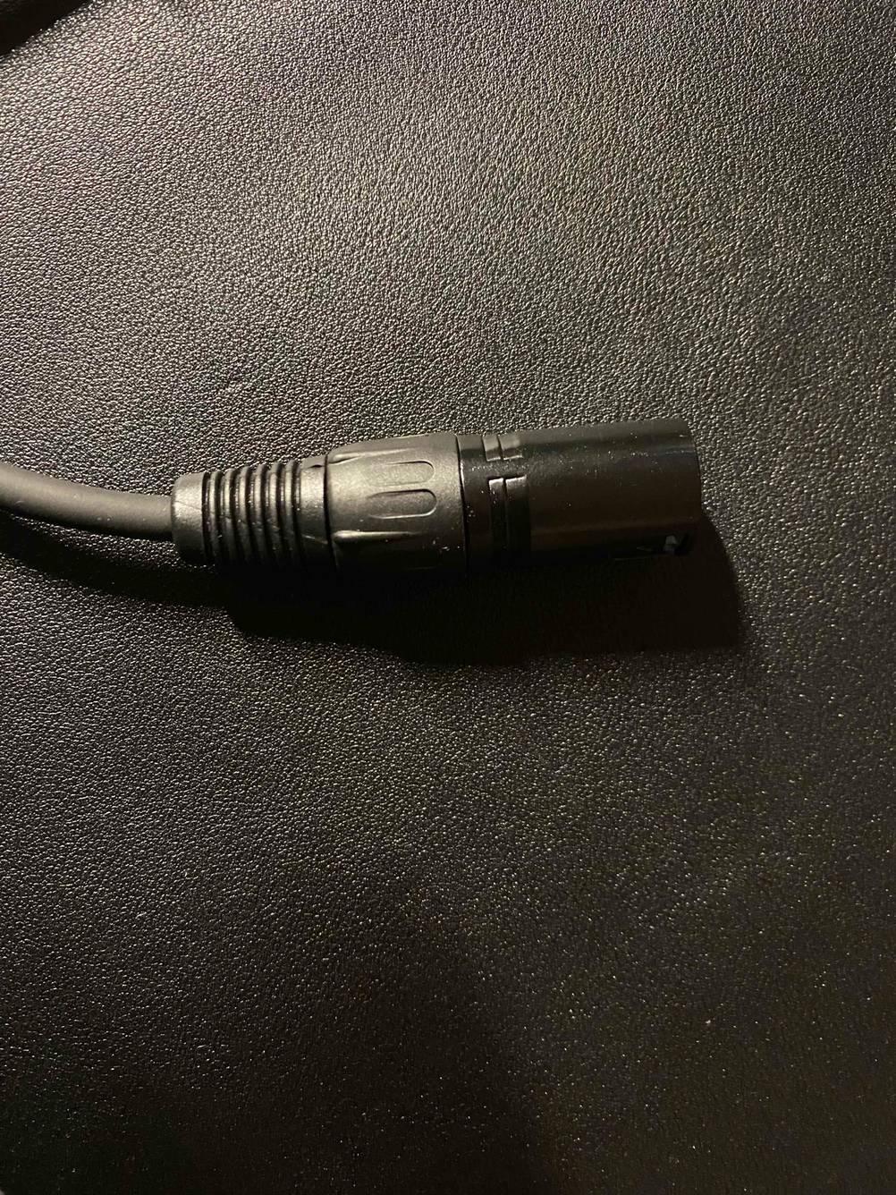 Detailaufnahme des getesteten XLR-Kabel auf den XLR-Male auf einer dunklen Fläche.