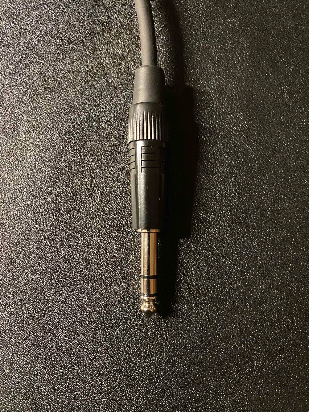 XLR-Kabel getestet: Detailaufnahme des Klinkensteckers auf einer dunklen Oberfläche.
