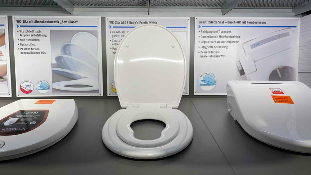 Ein getesteter Familien-WC-Sitz von vorne mit hochgeklapptem Deckel und dem sichtbaren Kindersitz.