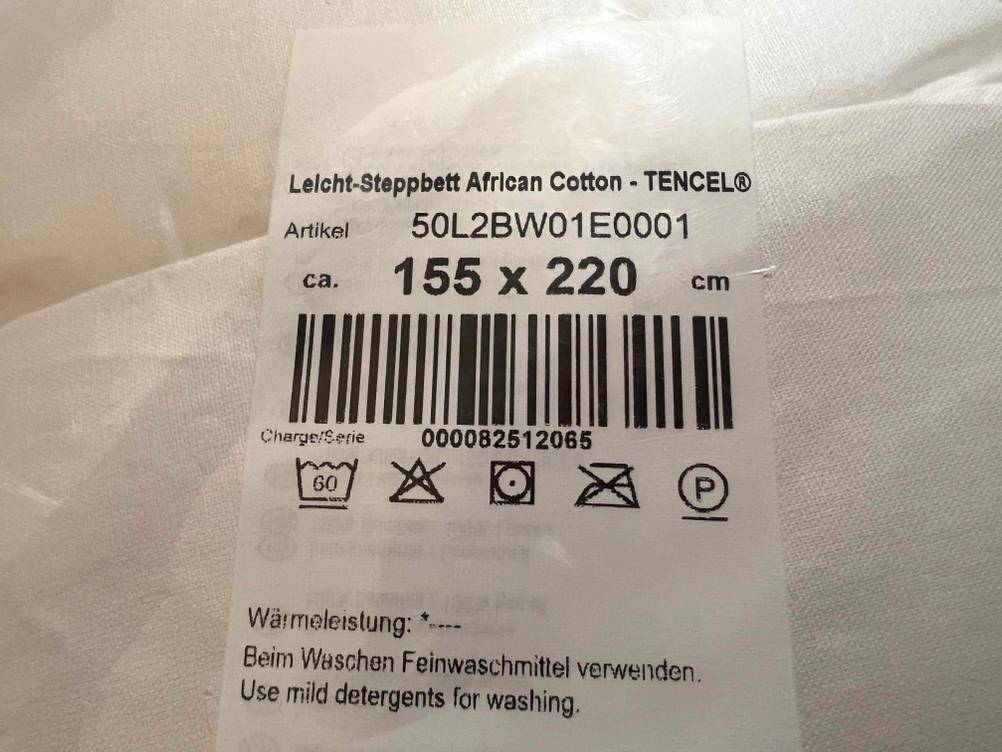 Bettdecke in 155x220 cm getestet: Nahaufnahme des Labels mit Größenangaben und Waschhinweisen.