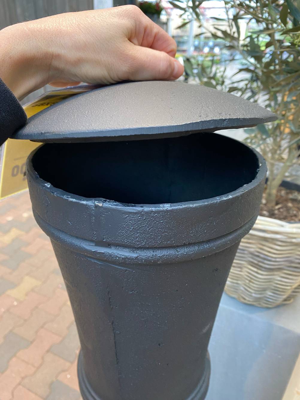 Terrassenofen-Test: Eine Hand öffnet den Deckel des Abzugs.