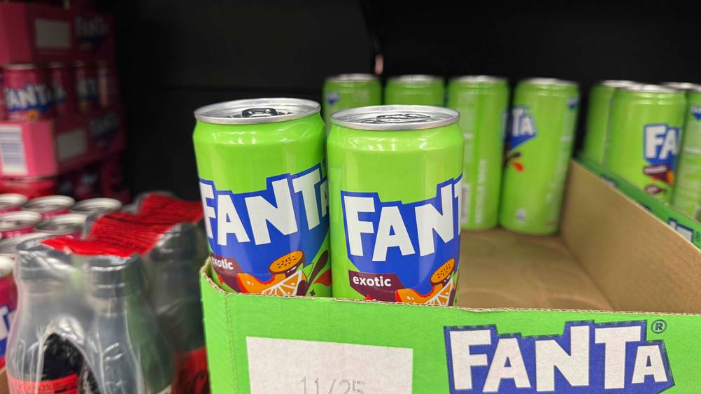Fanta im Test: Mehrere Dosen in einem Karton in einem Regal.