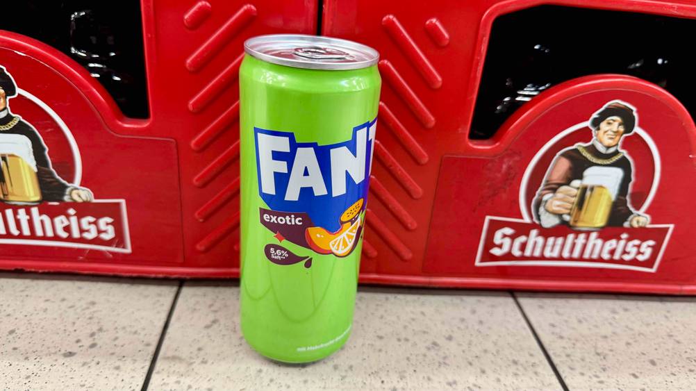 Eine Dose Fanta im Test vor Getränkekästen auf dem Boden.