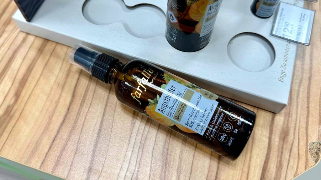 Raumspray-Test: Eine Flasche liegt quer auf einer Holzfläche.