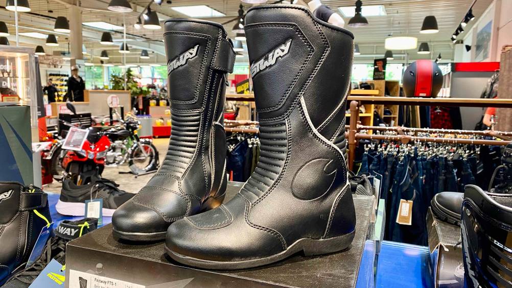 Ein Paar getestete Motorradstiefel von schräg vorne auf einem Karton in einem Verkaufsladen.