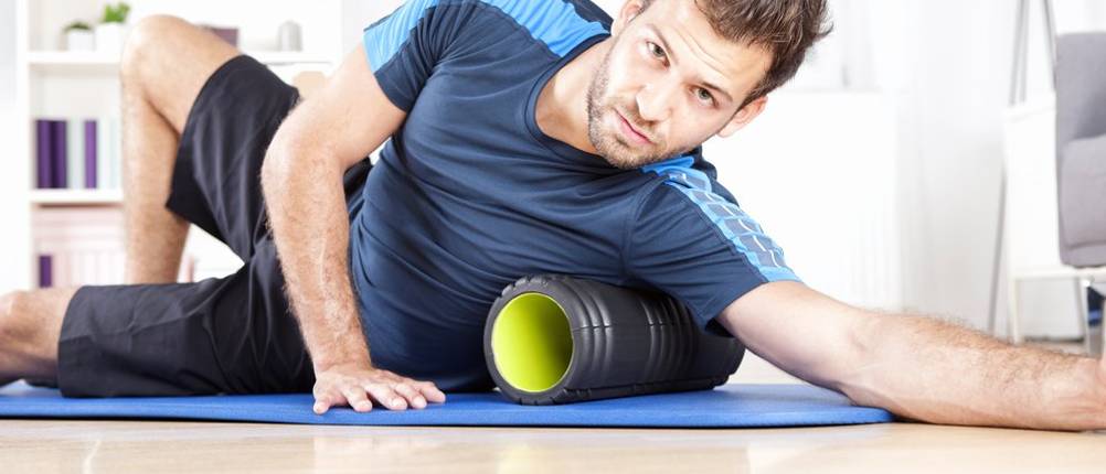 Faszienrollen-Set-Test: Ein Mann trainiert mit einer Faszienrolle auf einer Matte. 