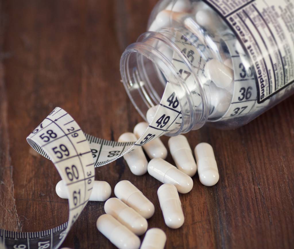 Fatburner-Test: In einer Glasdose befinden sich Kapseln und ein Massband. 