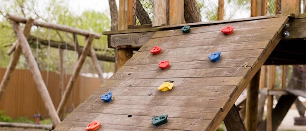 Fatmoose-Spielturm-Test: Eine Kletterwand als Aufgang zu einem Spielturm aus Holz.