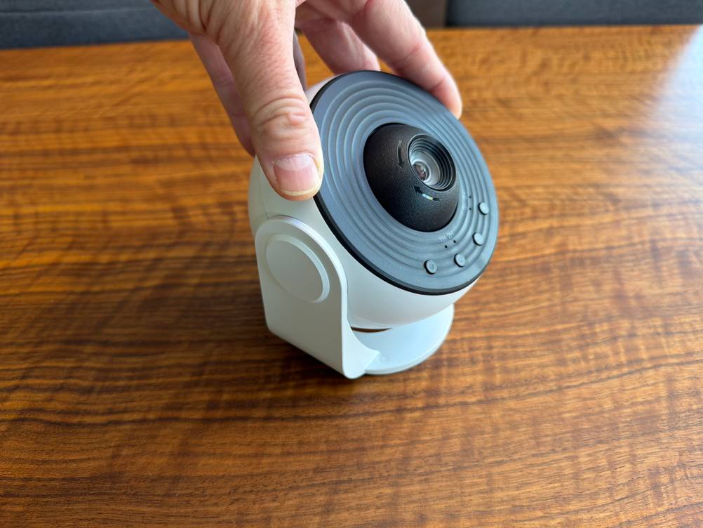 Eine Hand hält den Febotak-Aurora-Projektor L03 fest.