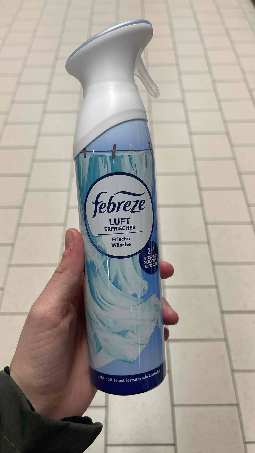 Eine Hand hält eine Flasche getesteten Febreze-Lufterfrischer für Wäsche.
