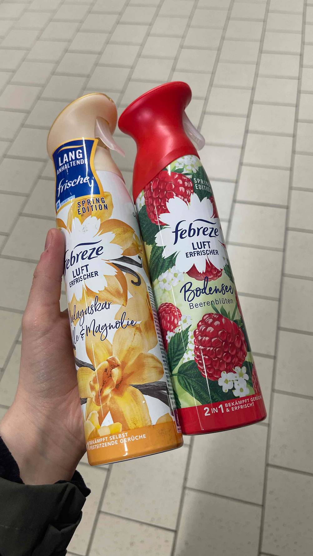 Im Test: Eine Hand hält zwei Flaschen Febreze-Lufterfrischer.