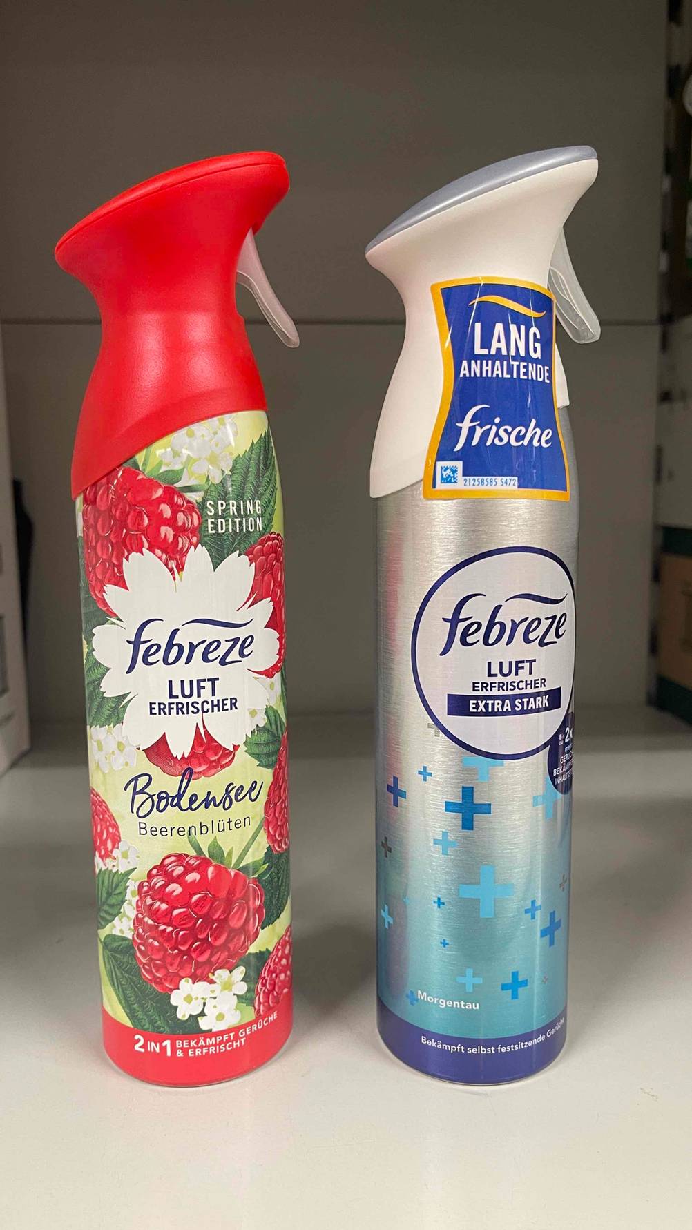 Eine Flasche Febreze-Lufterfrischer mit Himbeeren steht zum testen neben einer blauen.