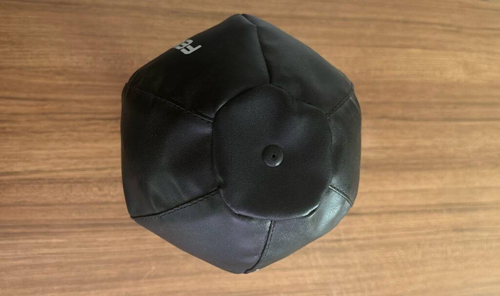 Ansicht von oben auf einen schwarzen getesteten Punchingball vor einer Holzoberfläche.