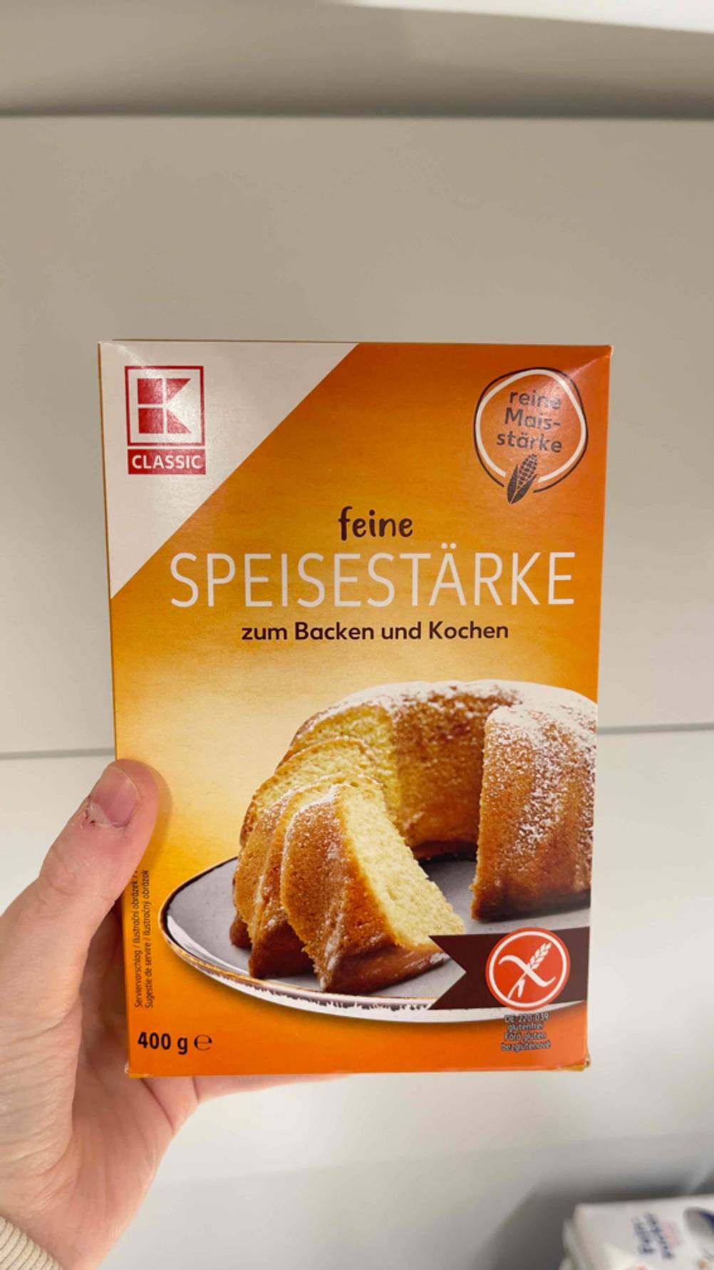 Eine Hand hält eine Packung getestete Speisestärke.