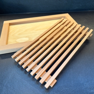 Das Feinholz-Brotschneidebrett steht mit Deckel auf einer Arbeitsplatte