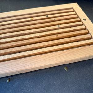 Auf dem Feinholz-Brotschneidebrett liegen Krümel