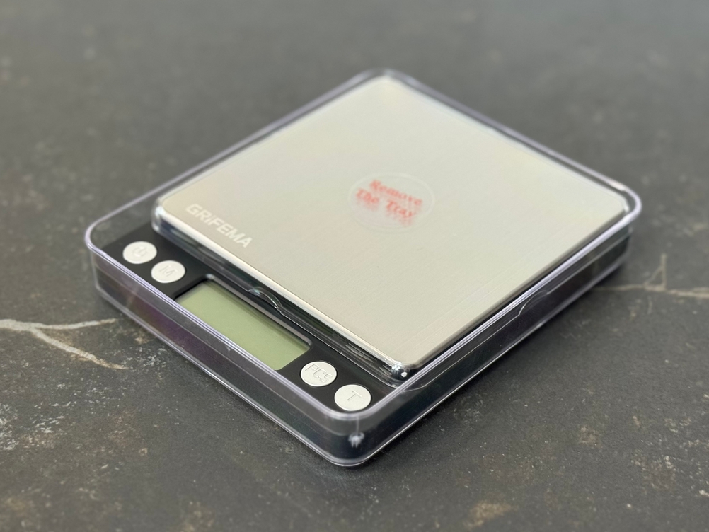 Die getestete Feinwaage von Grifema in beiden Plastikschalen geschützt.