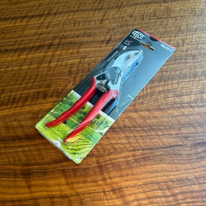 Die Felco F-2 liegt in ihrer Verpackung auf einem Holztisch