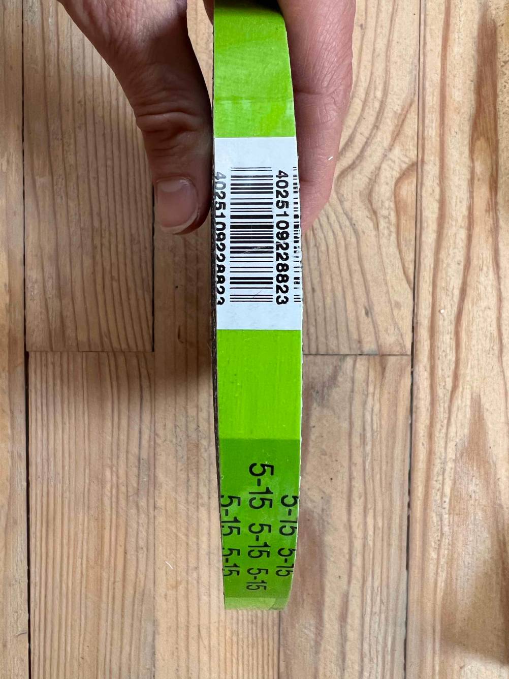 Eine Hand hält eine Rolle der getesteten Fensterdichtung mit dem Barcode nach oben.