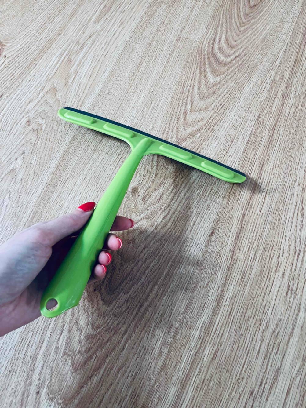 Eine Hand hält einen getesteten Fensterputzer.