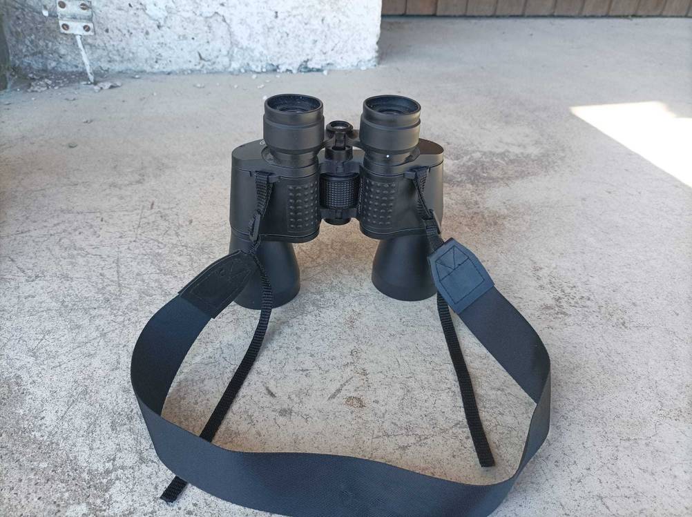 Ein getestetes Fernglas 10x50 steht auf einem Betonboden.