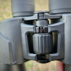 Nahaufnahme des Scharniers und des zentralen Fokussierrads des Olympus-10x50-S-Fernglases.