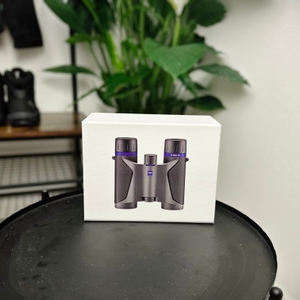 Die Originalverpackung des Zeiss-Terra-ED-Pocket-Fernglases steht auf einem Tisch. Die Verpackung zeigt ein Bild des Fernglases und hebt seine kompakte Bauweise hervor.