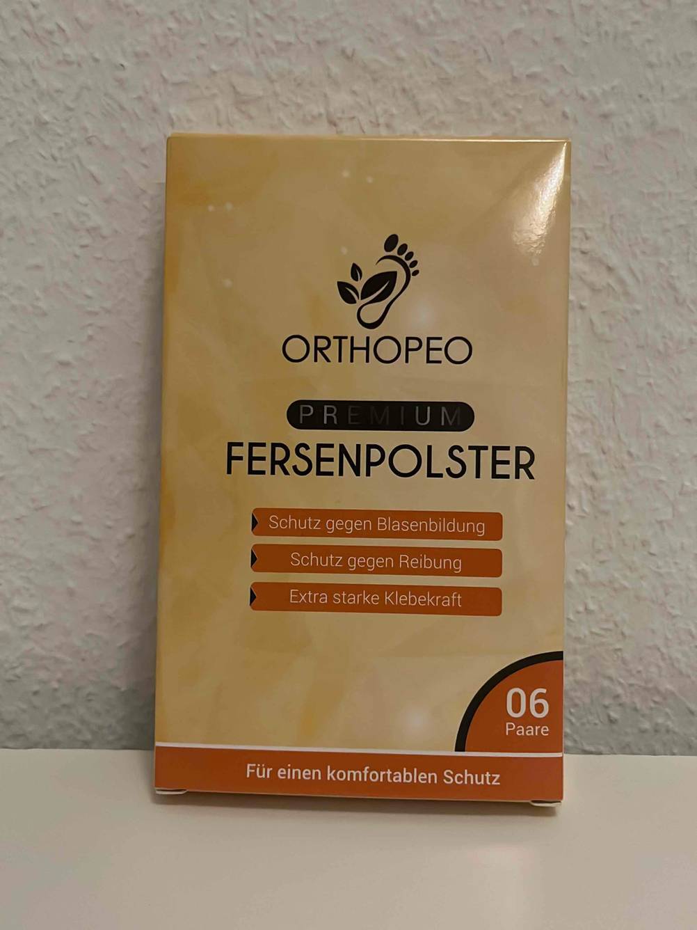 Eine Packung des getesteten Fersenpolsters vor einer hellen Wand.