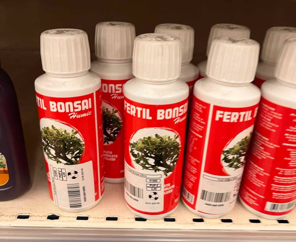 Verkaufsregal mit mehreren Flaschen mit flüssigem Bonsai-Dünger im Test der Marke Fertil.