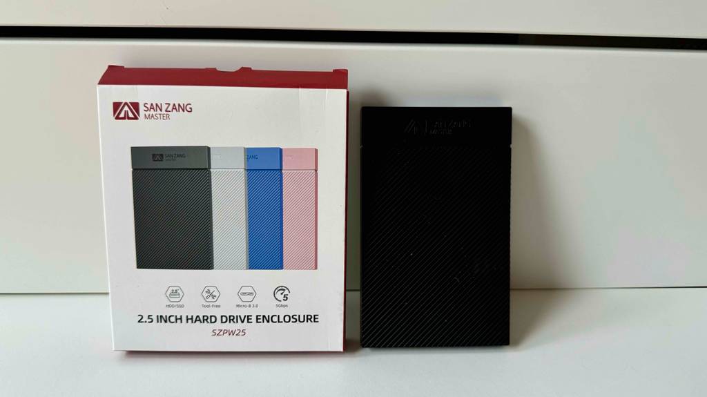 Festplattengehäuse getestet: Eine Gehäuse steht neben seiner Originalverpackung vor einer hellen Wand.