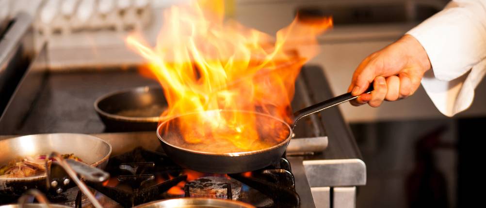 Fettbrandlöscher im Test: Flammen steigen aus einer Pfanne auf.