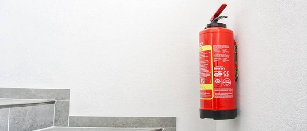 Fettbrandlöscher im Test: Ein Feuerlöscher hängt an einer Wand.