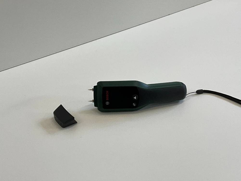 Feuchtigkeitsmessgerät getestet: Ein Gerät auf der Seite liegend auf einer hellen Fläche.