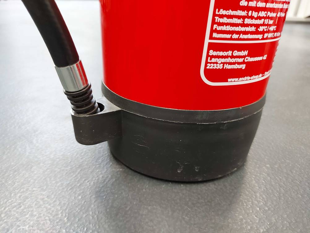Im Test: Unterer Teil eines Feuerlöscher mit Befestigung für Löschpistole.