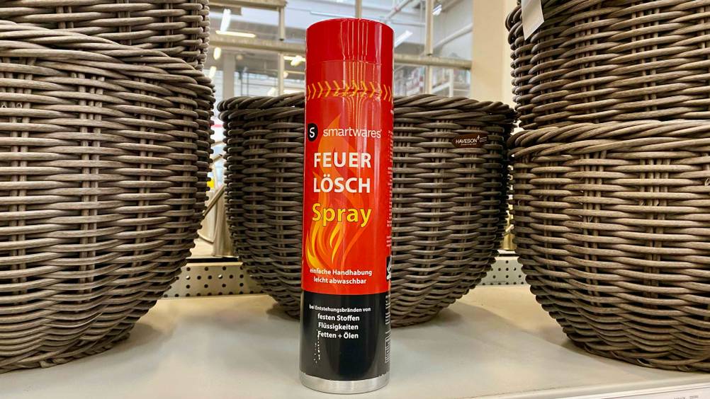 Ein getestetes Feuerlöschspray befindet sich zwischen Bambuskörben auf einem Regal. 