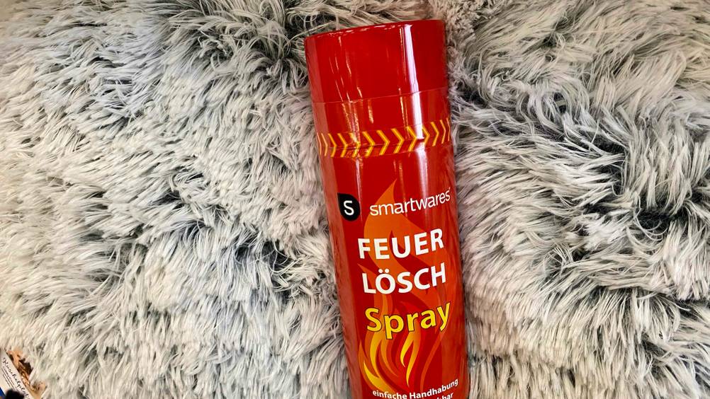 Auf einem Teppich liegt ein getestetes Feuerlöschspray.