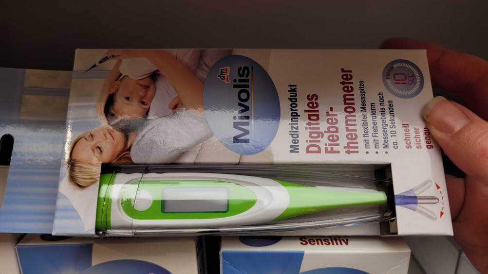 Getestet: Ein Fieberthermometer liegt horizontal in einem Regal.