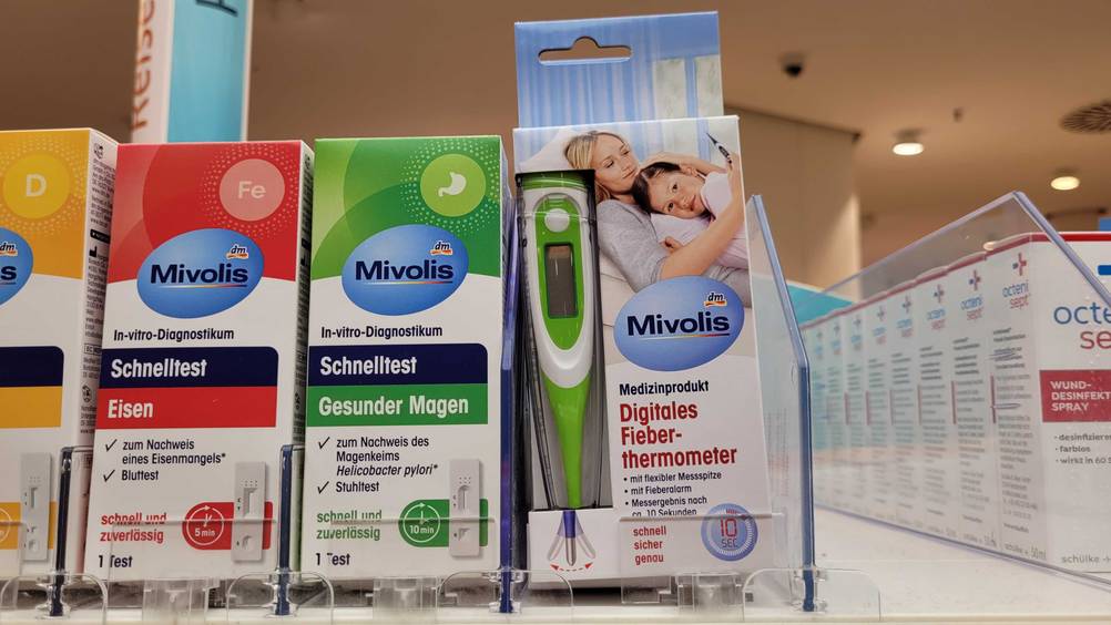 Ein getestetes Fieberthermometer verpackt, neben anderen Produkten im Regal.