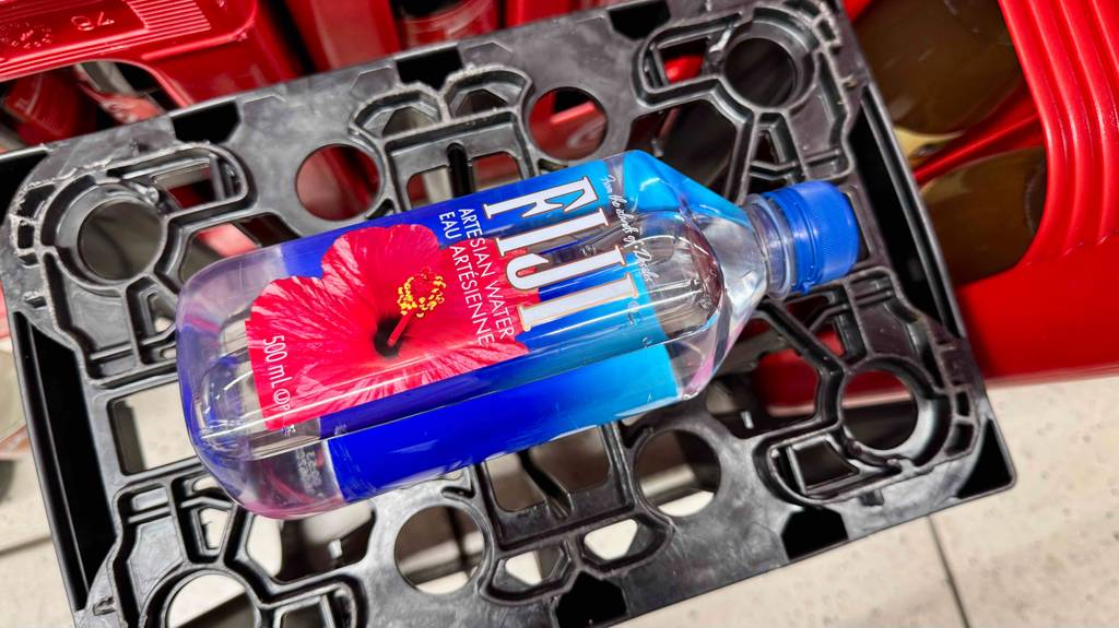 Quellwasser getestet: Eine Kunststoffflasche mit FIJI-Wasser liegt auf einem schwarzen Getränkekasten.