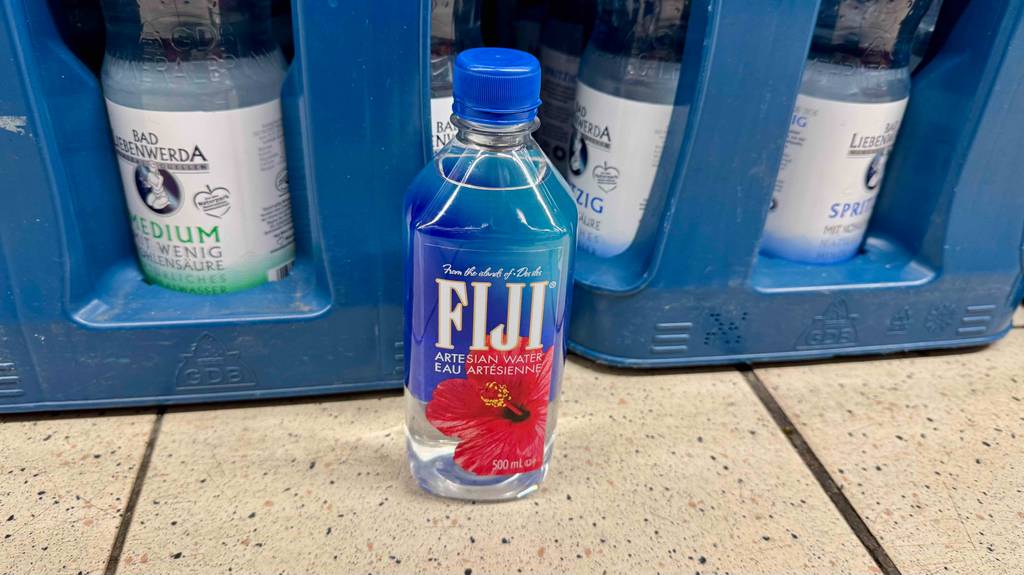 Quellwasser-Test: Eine Kunststoffflasche mit FIJI-Wasser steht vor zwei blauen Getränkekästen.
