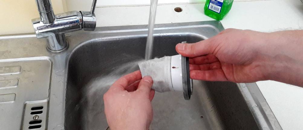 Severin-Staubfilter wird über einem Waschbecken händisch gereinigt.