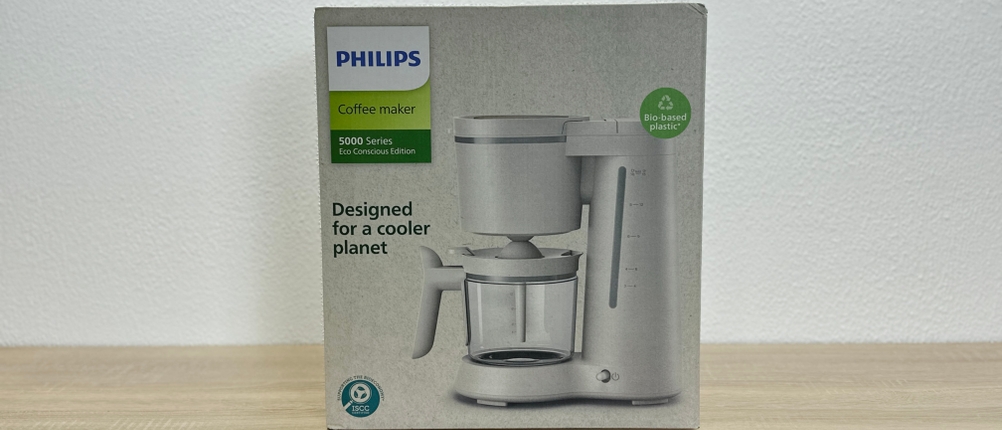 Die Verpackung der Philips HD5120 zeigt das Produktbild und Hinweise zur umweltfreundlichen Herstellung. Sie steht auf einer Holzfläche.