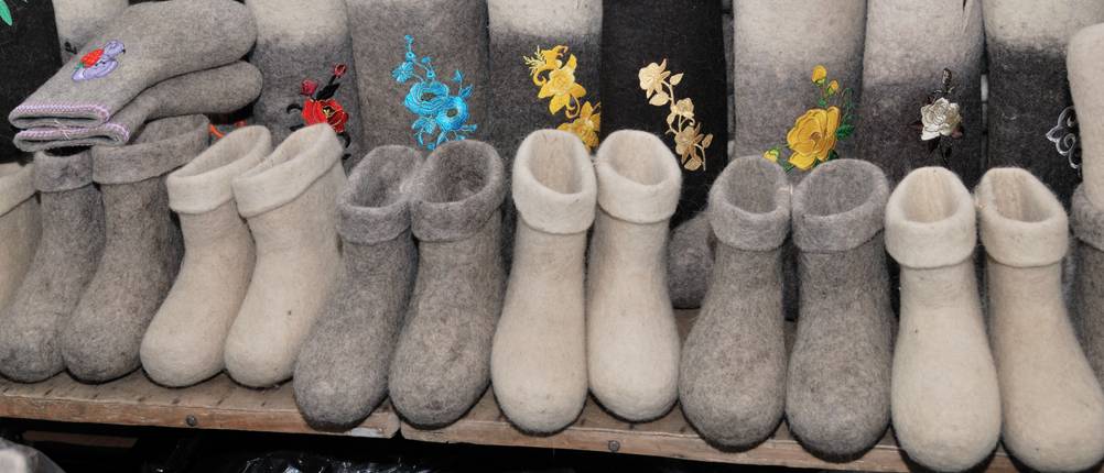 Filzstiefel im Test: Einige Filzstiefel stehen aufgereiht auf einem Holzbrett.