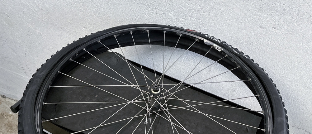 Ein Fincci-Gravel-Fahrradreifen 29 Zoll wird auf eine Felge gezogen. Die Hand führt den Reifen kontrolliert entlang der Felgenkante.