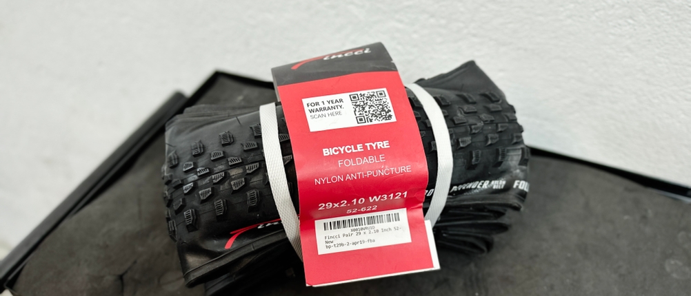 Im Bild sind zwei Fincci-Gravel-Fahrradreifen 29 Zoll inklusive Etikett und Verpackung zu sehen. Die Reifen sind zusammengebunden.