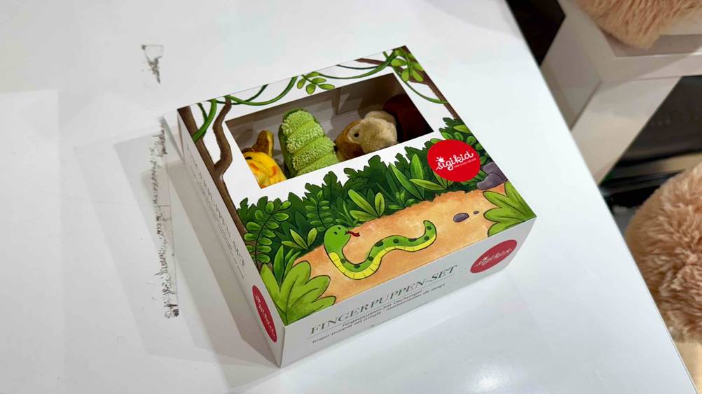 Auf einer hellen Fläche liegt die Packung Fingerpuppen im Test mit den Boden nach vorne.
