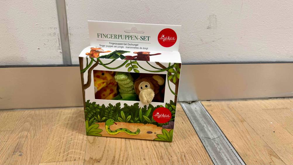 Fingerpuppen im Test: Die Packung steht vor einer weißen Wand auf dem Boden.
