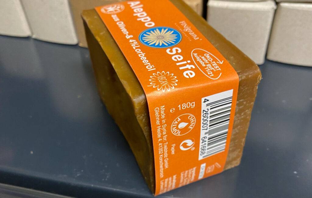 Aleppo-Seifen im Test: Nahaufnahme einer orangefarbenen Verpackung inklusive der Gewichtsangabe von 180 g.