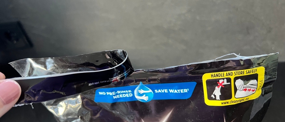 Die Verpackung der Finish Ultimate Infinity Shine Spülmaschinentabs wird von einer Hand geöffnet